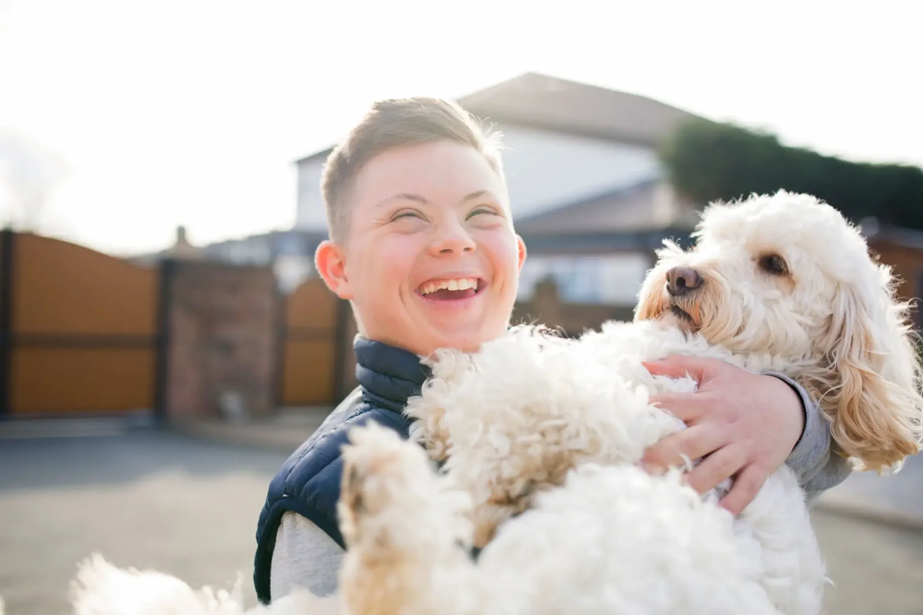 Smiling child holding a fluffy white dog